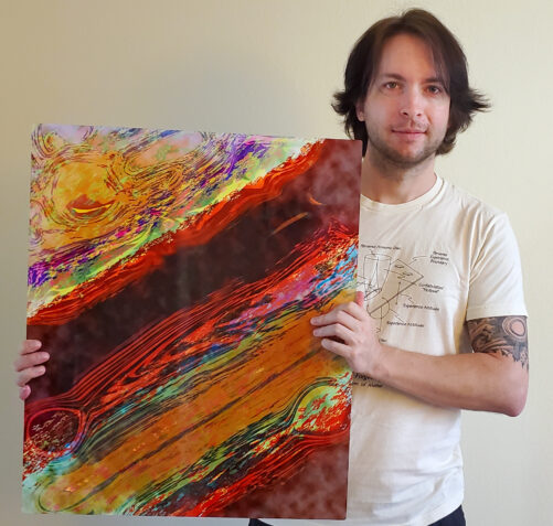 Perplexia artist Ethan J Hulbert holding Class Seven Atmospheric Bands in aluminum.