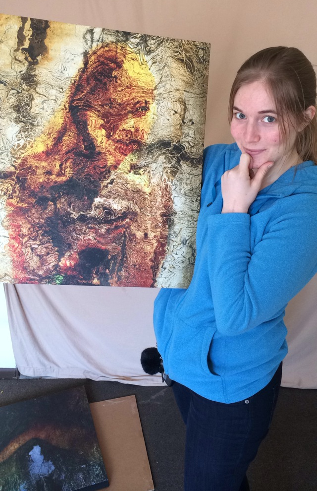 Photograph of the young woman subject of Otherworldly holding up the canvas print and recreating the pose.