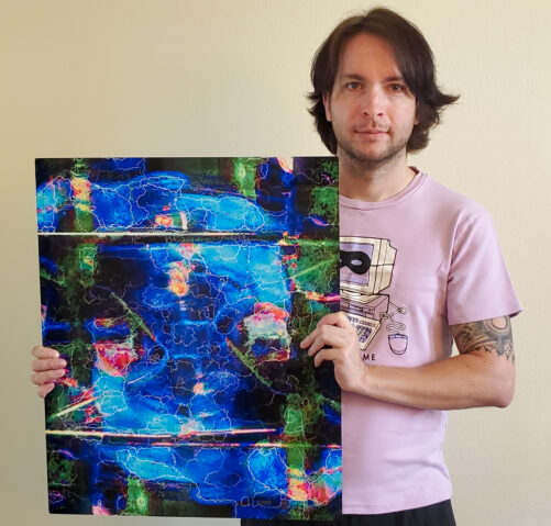 Perplexia artist Ethan J Hulbert holding an aluminum misprint of Sapphire Plasmacoil.